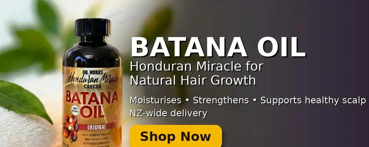 Dark amber glass bottle of batana oil with a black cap and label featuring red, gold, and white text.